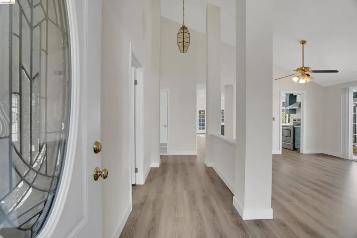 Foyer with light wood-style floors, lofted ceiling, and a ceiling fan