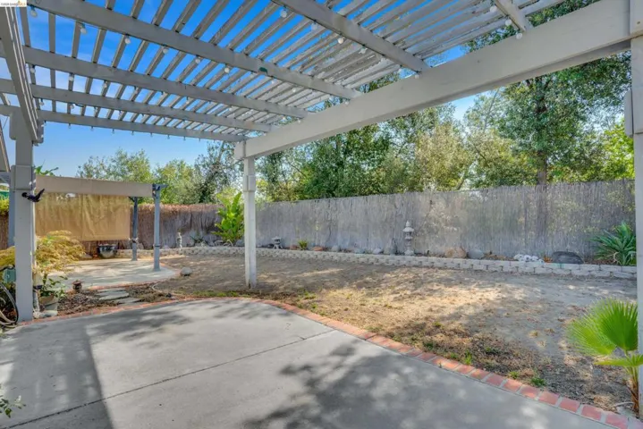 Fenced backyard with a pergola and a patio