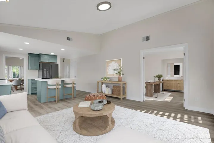 Living room with light wood-style flooring, crown molding, vaulted ceiling, and recessed lighting