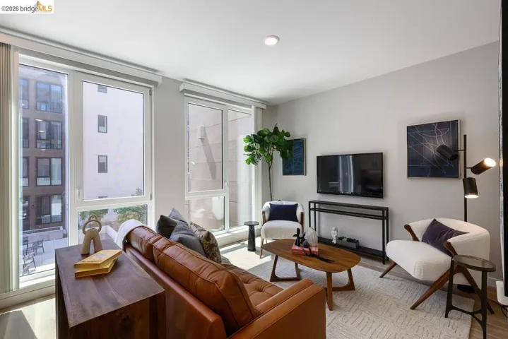 Living area with light wood-type flooring and floor to ceiling windows