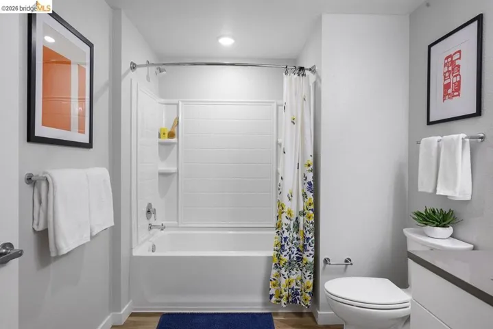 Full bathroom with shower / bath combo, vanity, and wood finished floors