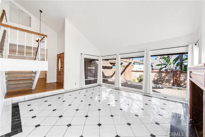 Elegant living space vaulted ceilings, beautiful fireplace and a view of the front courtyard.