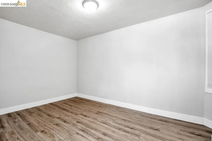 Spare room with baseboards and light wood-type flooring