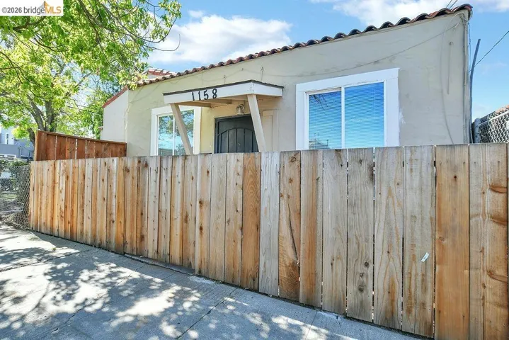 View of side of home featuring a tiled roof and stucco siding