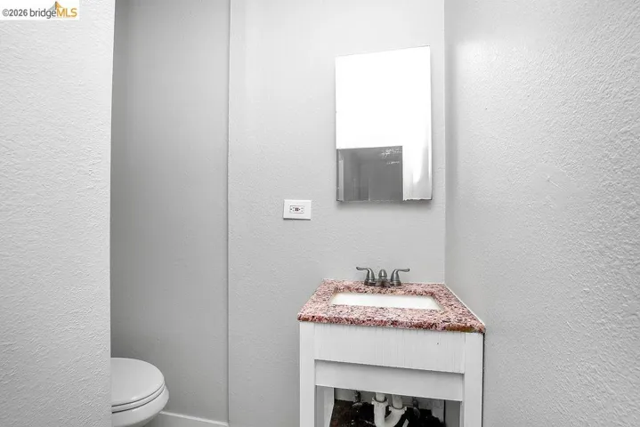 Half bath with vanity and a textured wall
