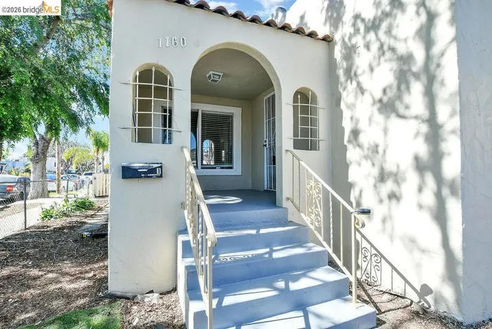 View of exterior entry with a tile roof and stucco siding