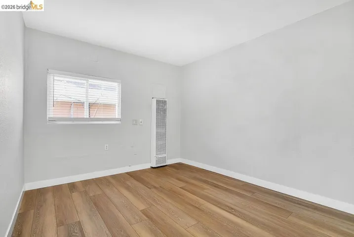 Spare room featuring light wood-style floors and a heating unit