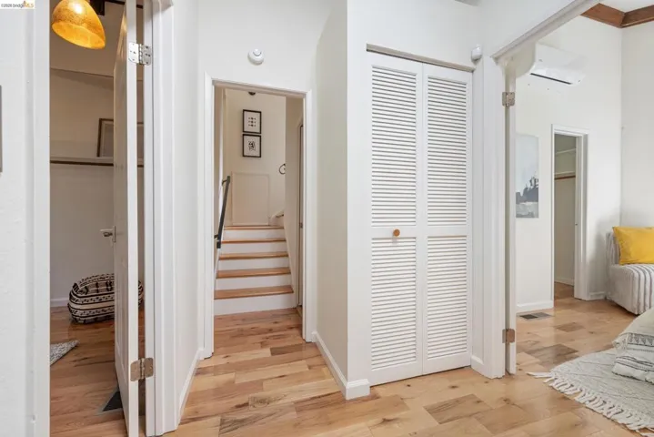 Hall with a mini split for heating / cooling and light wood finished floors