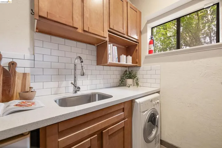 Laundry room with washer / clothes dryer and a textured wall