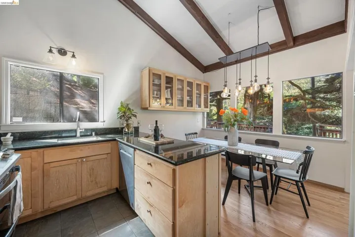 Kitchen with a peninsula, glass fronted cabinets, pendant lighting, stainless steel appliances, and plenty of natural light