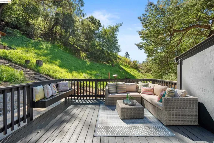 Wooden terrace with outdoor seating and view of scattered trees