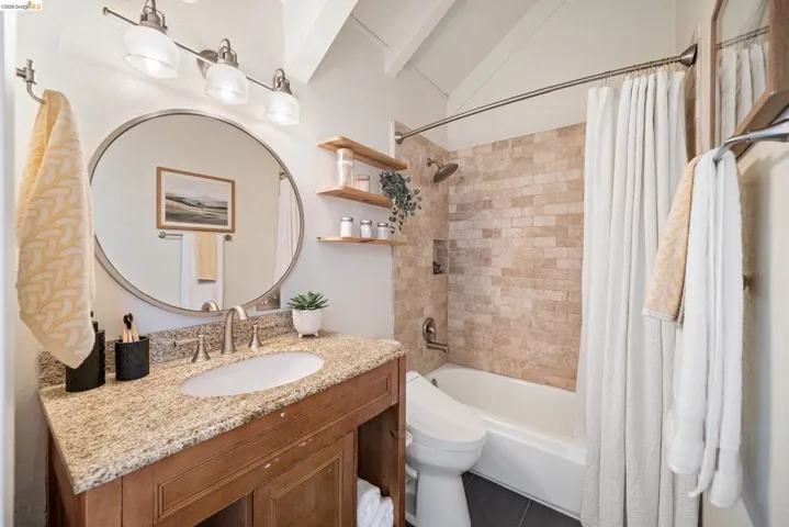 Full bath with vanity, shower / tub combo, and lofted ceiling with beams