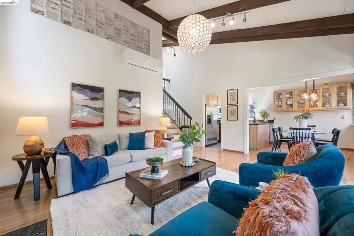 Living room with suspended lighting and light wood-type flooring