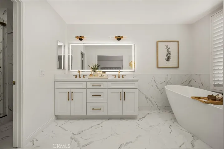 Primary bath has a backlit mirror and new light fixtures...details that make it an elegant space!