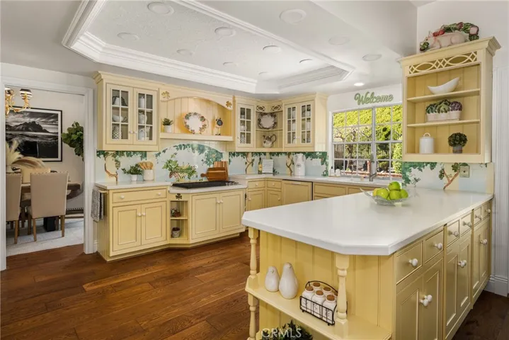 French, Country-inspired kitchen offers generous counter space made of corian, and ample storage.