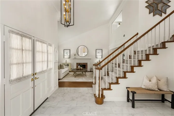 Living room fireplace with custom mantel and surround, as seen from the two story front entry.