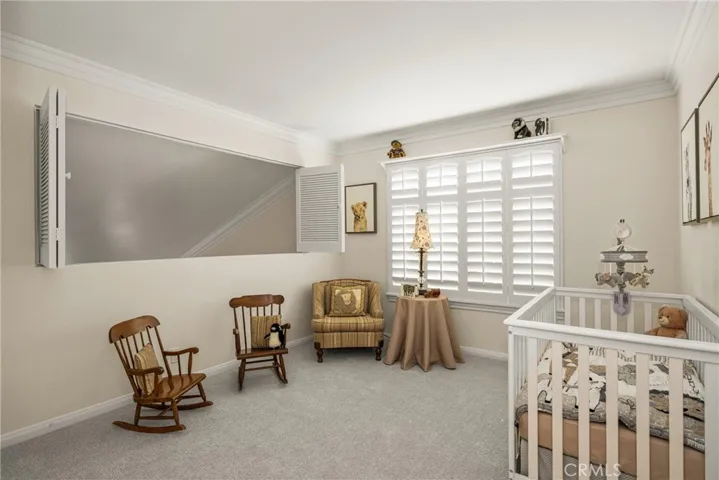 The nursery offers new carpet and paint, plantation shutters, closet and opens to the living room. This wall can be easily modified and converted into a solid wall for added privacy.