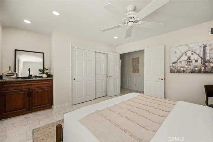 The spacious downstairs bedroom offers a sink with storage and closet.