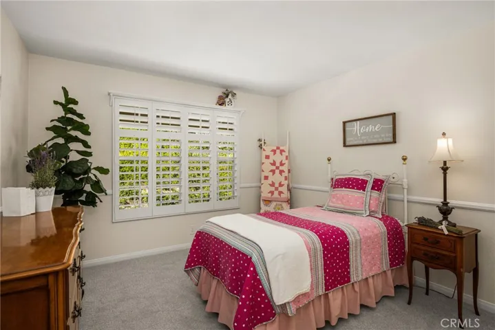Spacious middle bedroom next to hall bath has new carpet and plantation shutters.