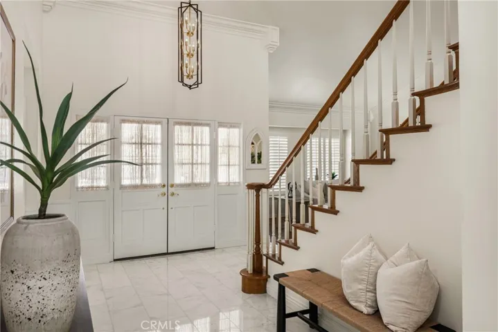 Front entry with a new chandelier and new, elegant, Carrera marble flooring.