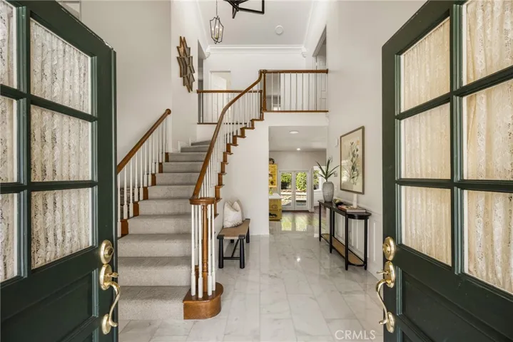 French doors welcome you to a stunning Carrera Marble covered entryway in this fabulous remodeled home!