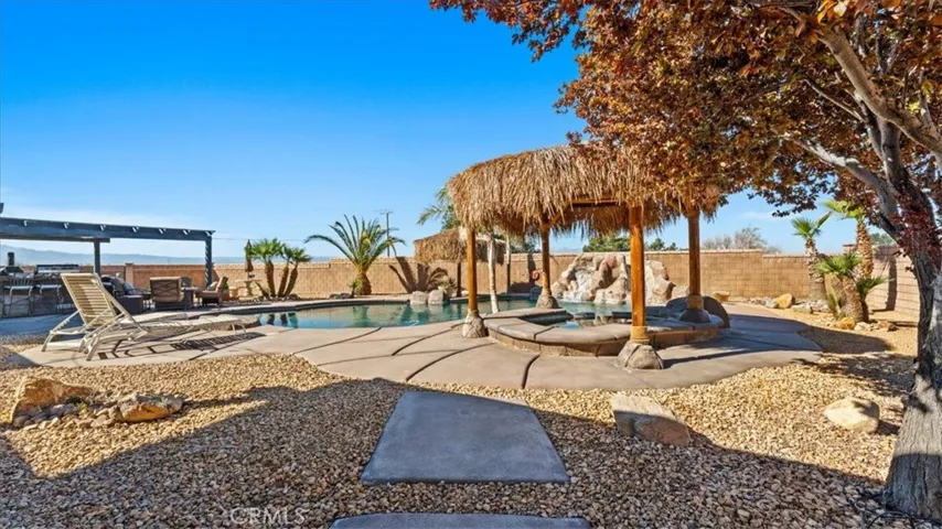 Backyard wide shot: Multiple outdoor living spaces designed for hosting and relaxation