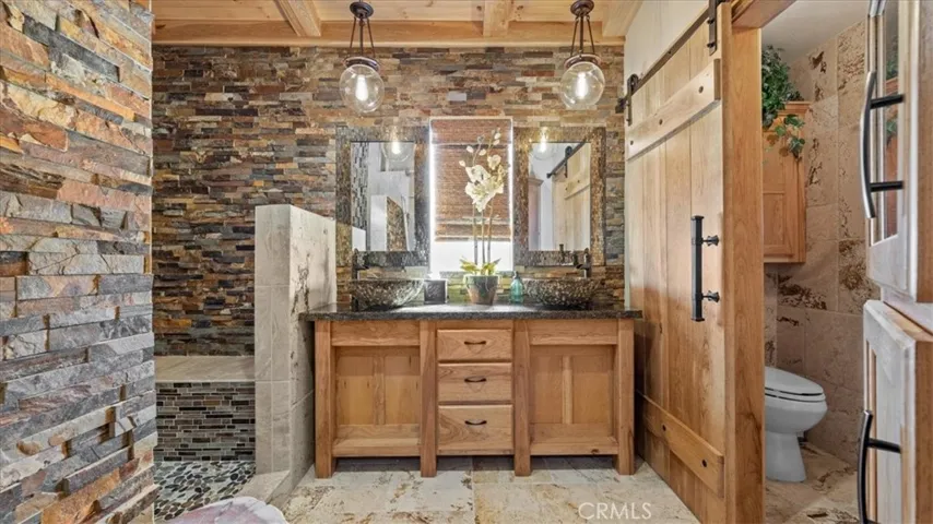 Primary bathroom: Ensuite bath featuring travertine surfaces and custom finishes