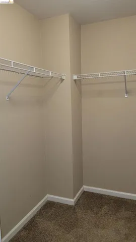 Walk in closet featuring dark carpet
