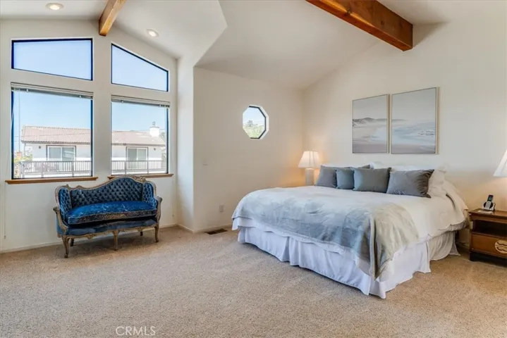 The large primary bedroom has a sitting area, ocean view and two closets. It also has access to the incredible back deck.
