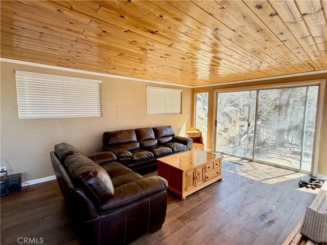Family room with beautiful knotty pine ceilings and slider to side deck and yard.