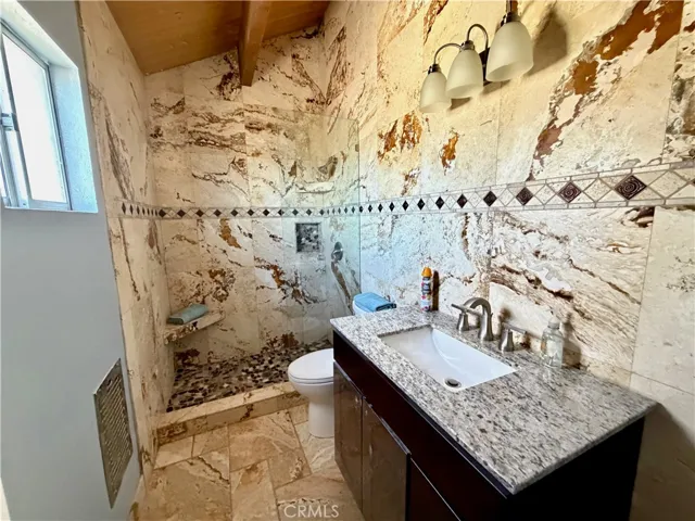 Full bathroom adorned with travertine tile.