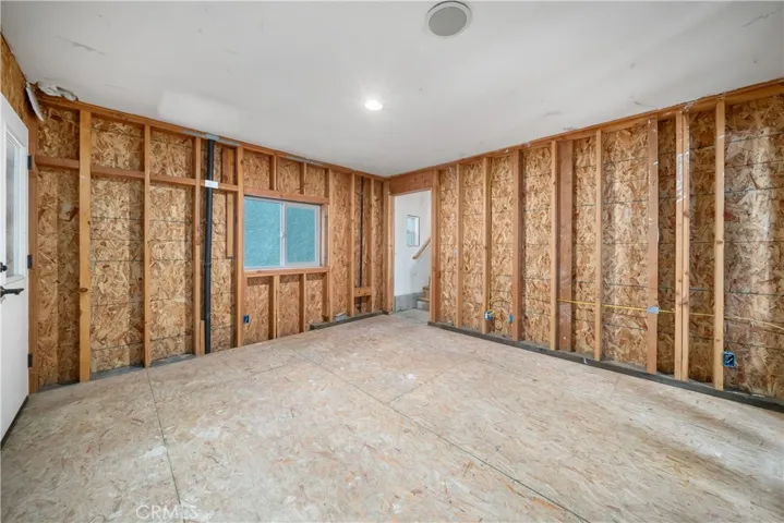 Unfinished room with plumbing and electrical in place. Could be a fourth bedroom or living area.