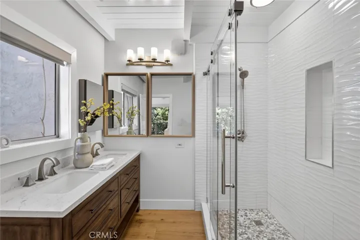 Primary Bathroom with dual sinks and low step shower