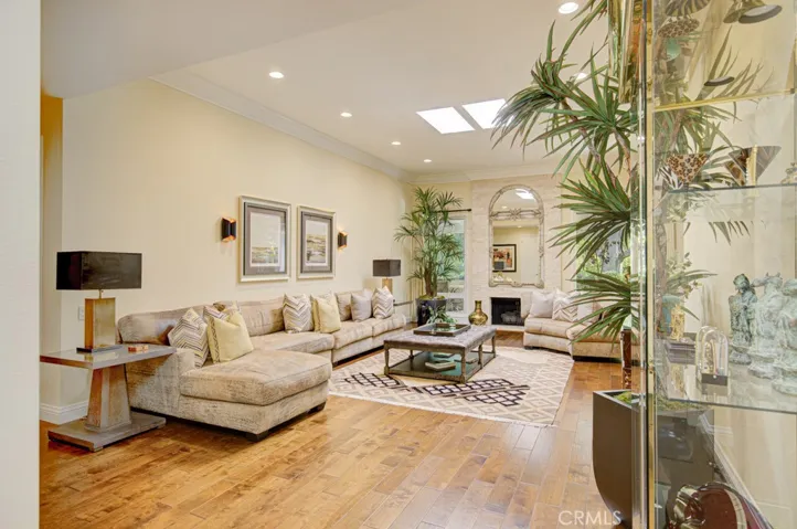 Living room has high 11' ft. ceilings and can easily accommodate multiple configurations of large furnishings. Note the gorgeous hardwood flooring, skylights and recessed lighting.