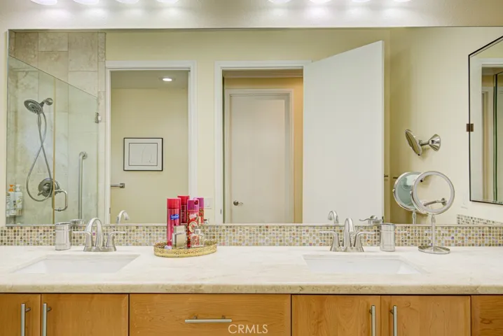 Primary bathroom has dual sinks, a granite countertop and stylish wood cabinetry.