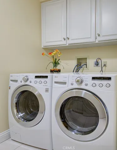 Laundry room has full-size LG washer-dryer and cabinet storage.