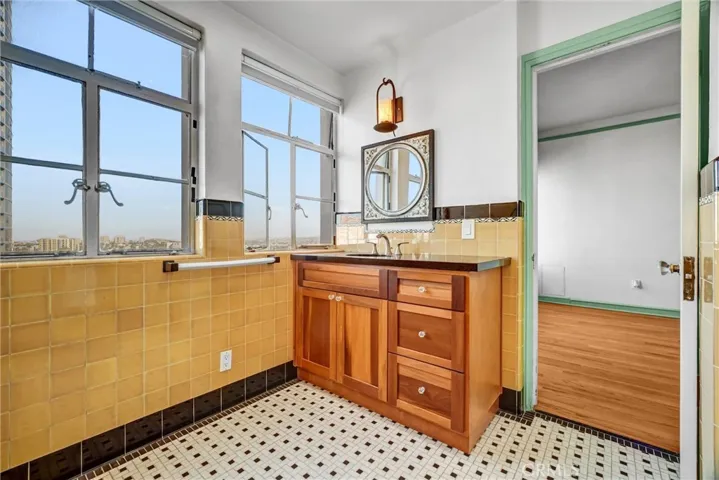 Beautifully remodeled bathroom with custom cabinetry, granite counter top and vintage inspired tile work to keep in tune with the era of the building.