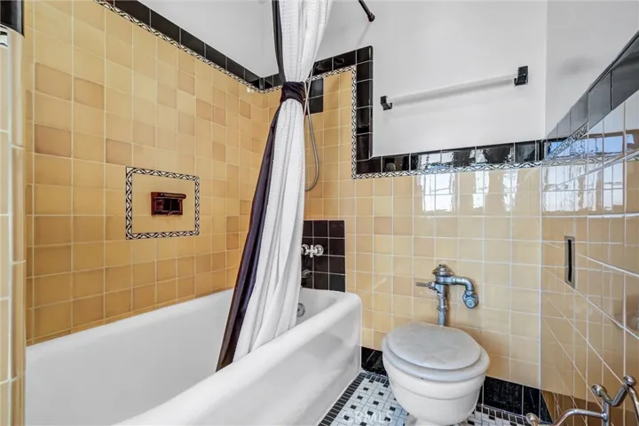 Beautifully remodeled bathroom with custom cabinetry, granite counter top and vintage inspired tile work to keep in tune with the era of the building.