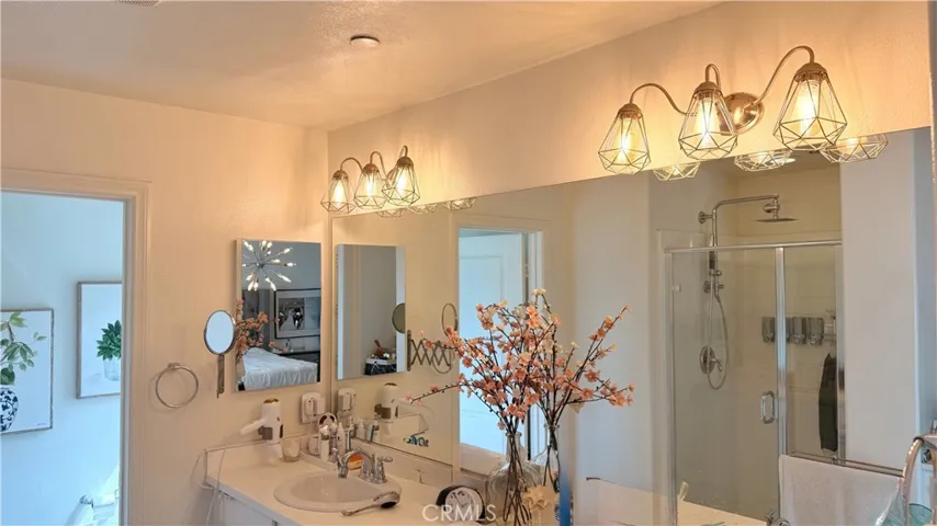 Primary bathroom with white cabinetry, pendant lighting, and Kohler rain shower system, Whittier CA
