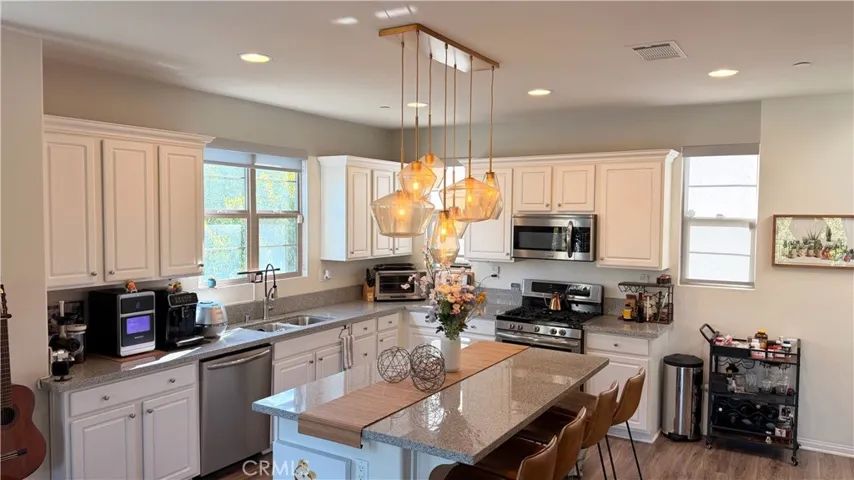 Kitchen with white cabinetry and open layout, tri-level townhome The Heights on Beverly Whittier
