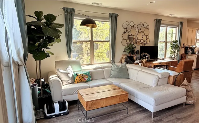 Spacious living room with warm toned wood flooring, The Heights on Beverly Whittier CA
