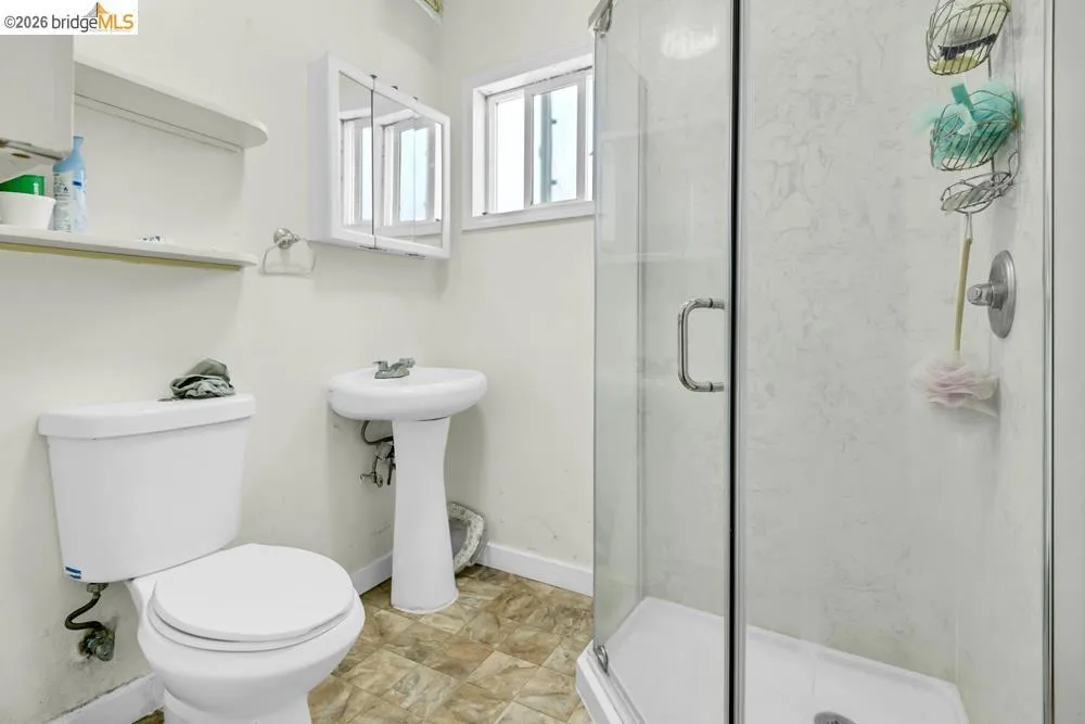 Full bath with a marble finish shower