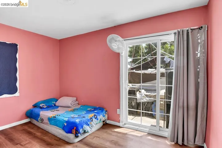 Bedroom with wood finished floors and baseboards