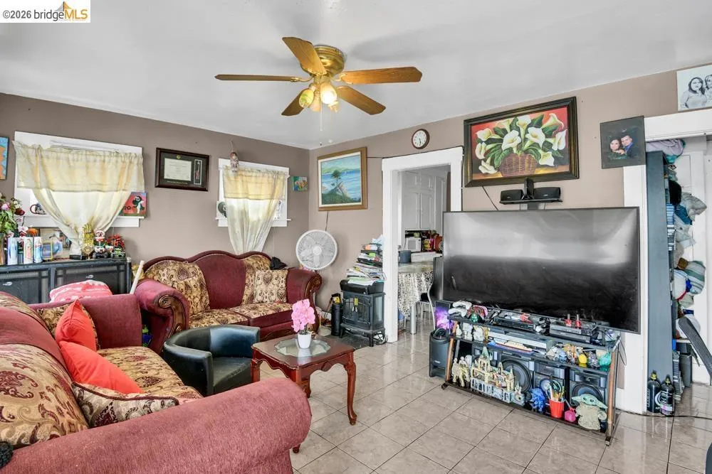 Tiled living room featuring a ceiling fan