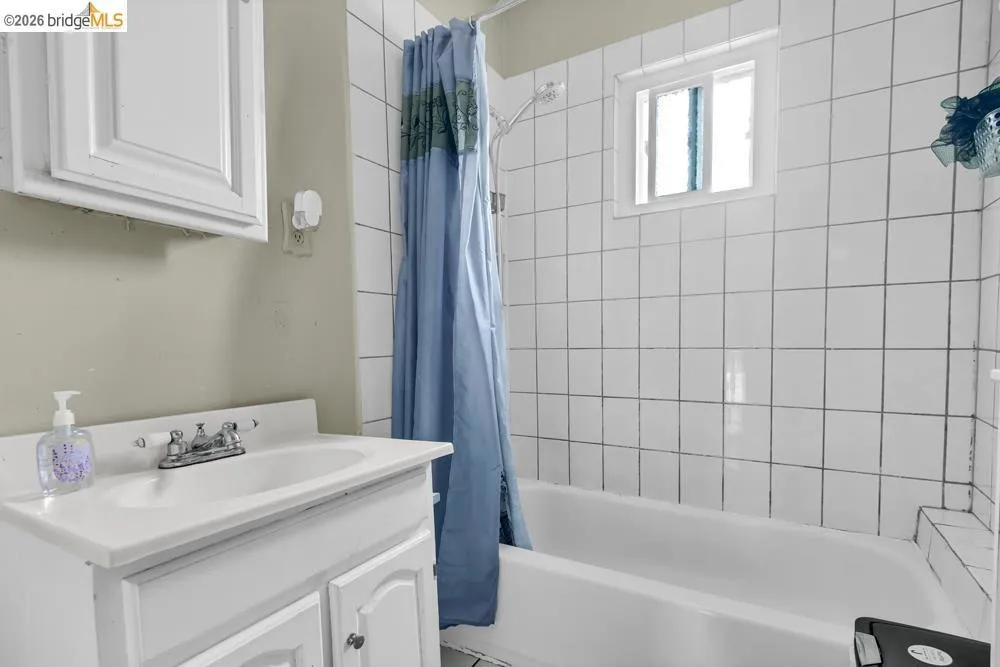 Full bath featuring vanity and shower / bath combo