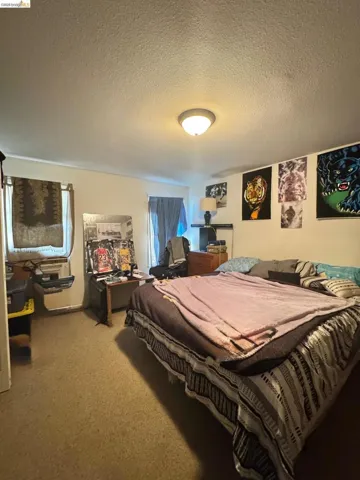 Bedroom featuring a textured ceiling and carpet floors