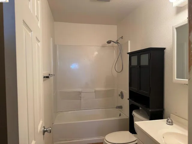 Bathroom featuring a white bathtub and shower combination with a handheld showerhead