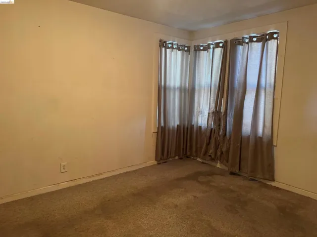 Neutral-toned wall finish with baseboard molding and a carpeted floor