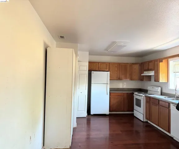 Kitchen featuring wood-finish flooring, natural wood cabinetry, and laminate countertops