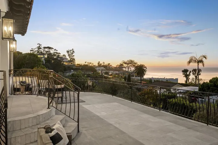Panoramic balcony with sweeping sunset views, where golden light settles over the ocean and coastal hills, creating an effortless setting for evening relaxation.